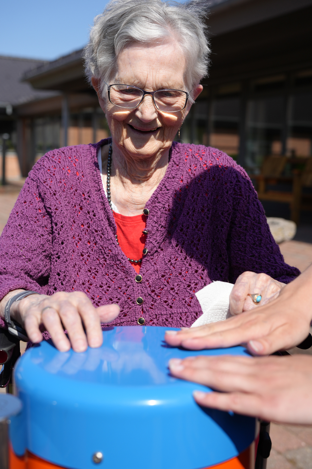 senior lady playing outdoor drums in a senior living home