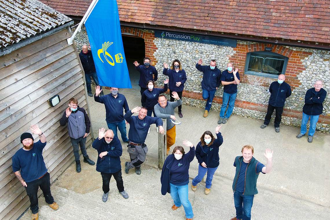 Percussion Play Team with Queens Award Flag (1140x760 Percussion Play Team - Queens Award Drone