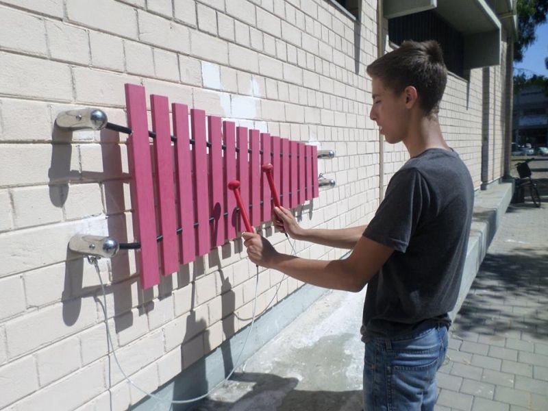 boy playing wall mounted marimba xylophone outside Tel Aviv Music Centre