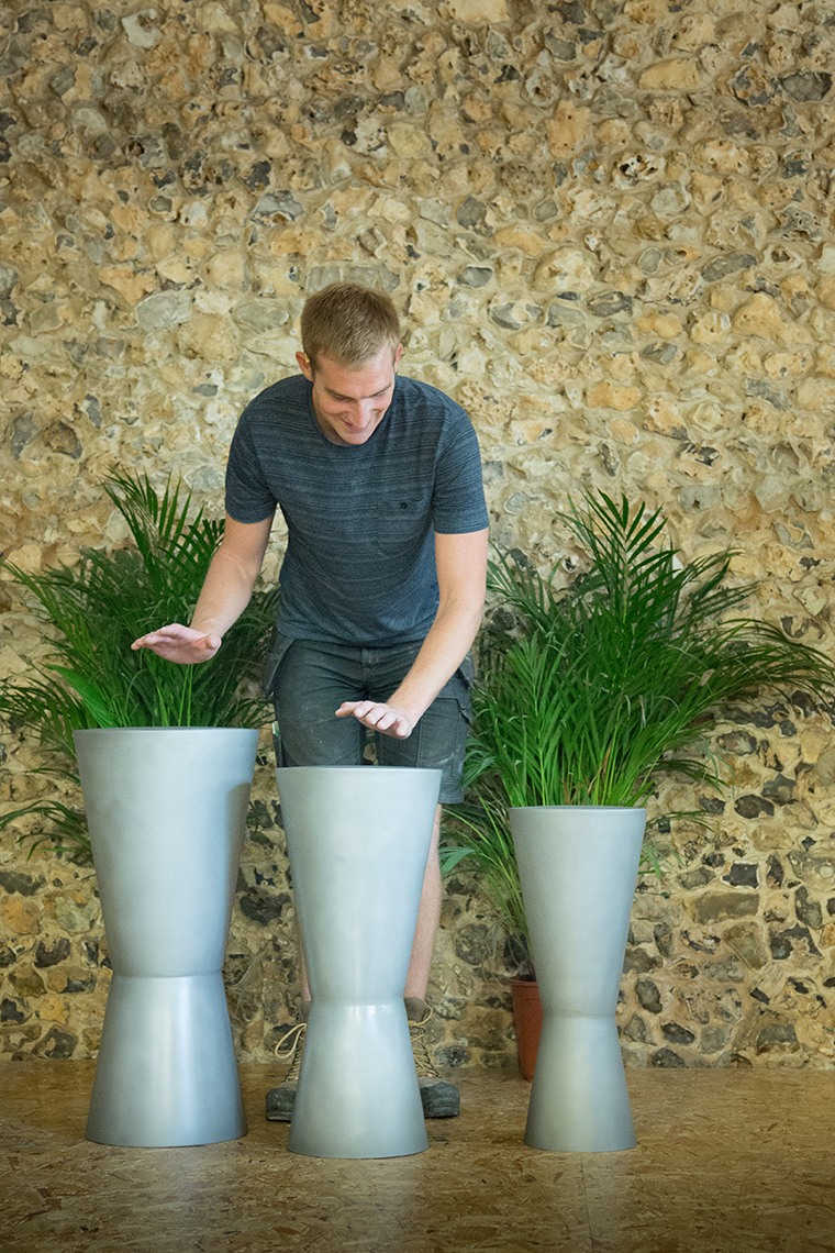 man playing a trio of outdoor stainless steel djembe drums