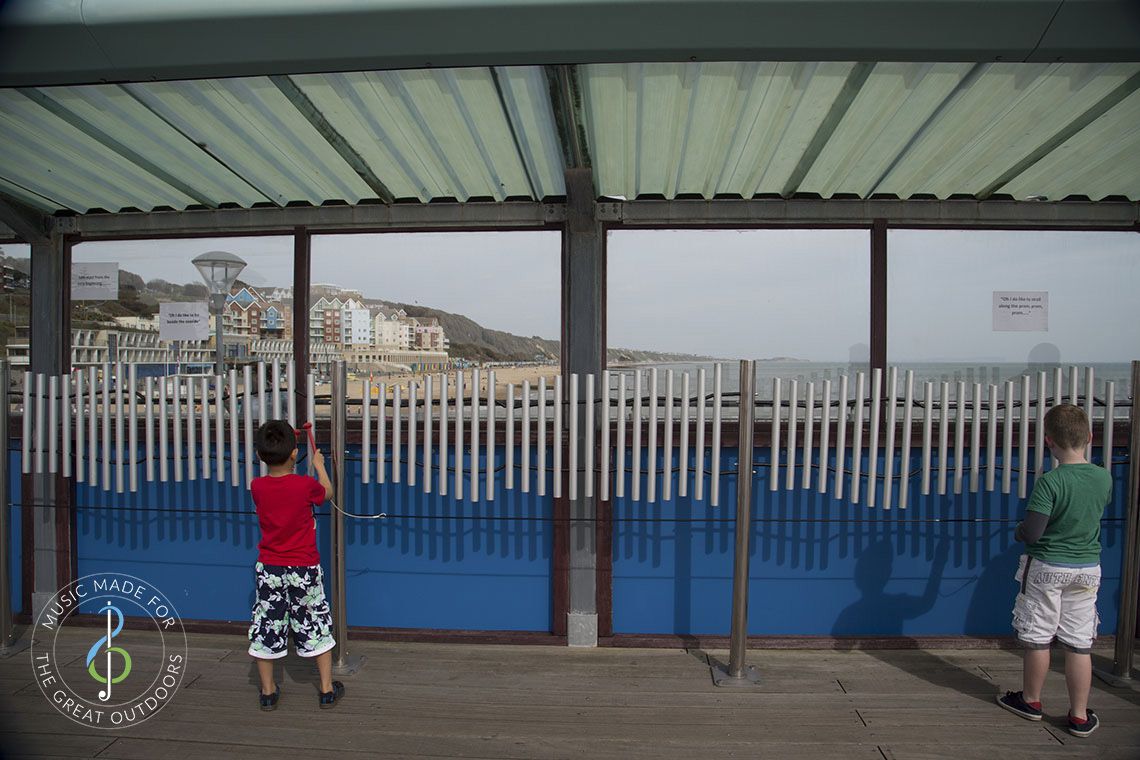 boys on boscombe pier playing seaside musical chimes that play 'Oh, I do like to be beside the seaside' 