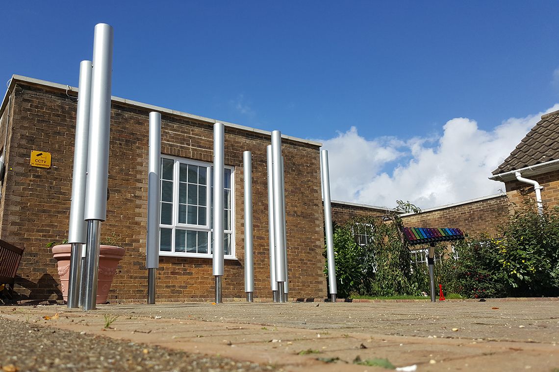 Tall silver chimes installed in a playground